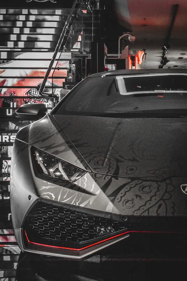 Matte grey supercar with tone-on-tone paisley art wrap, front view