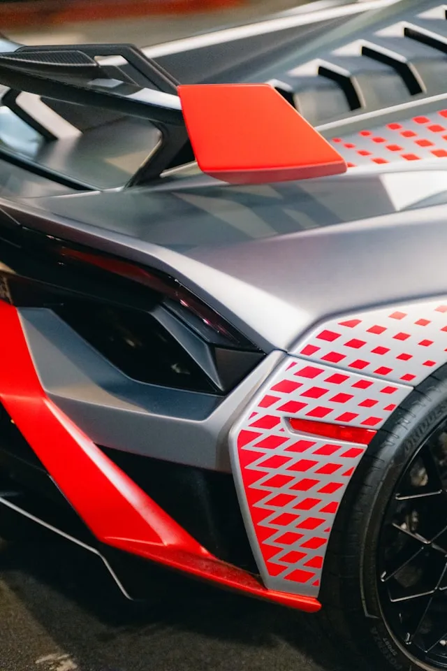 Satin grey supercar with red diamond-pattern fade graphics on the rear fender